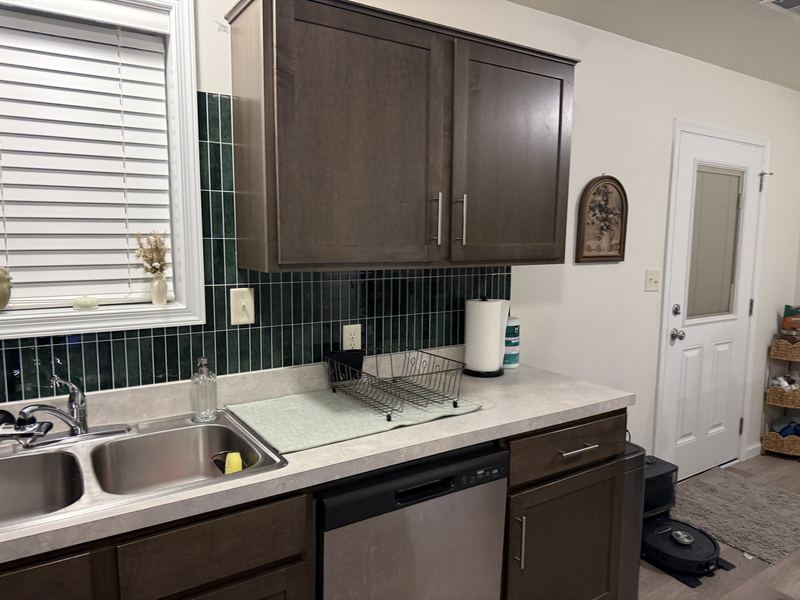 Wide view of the sink wall with finished green tile
